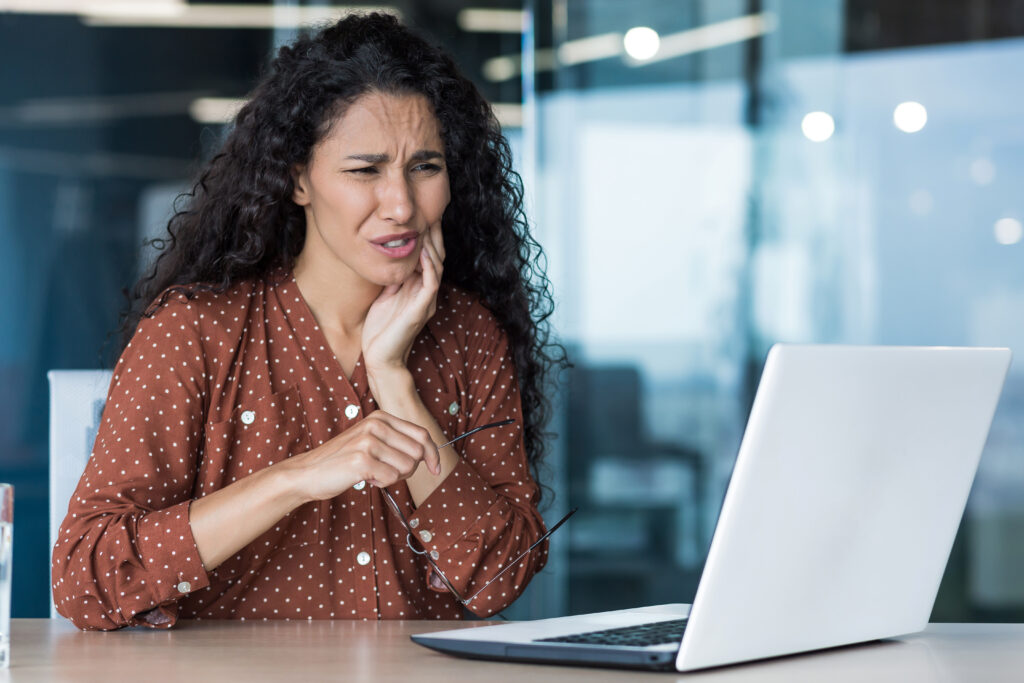 Beautiful business woman working inside office building, patient has severe toothache